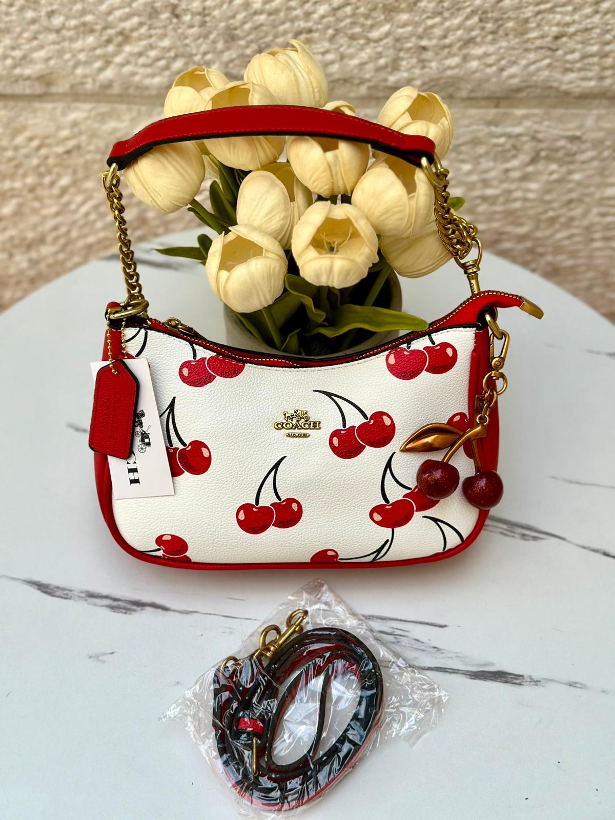 58bf9625-d6a2-40bb-8433-e06def80b83d شنتة كوتش مع كرزة مختومة 🍒🤍 - الصورة 1